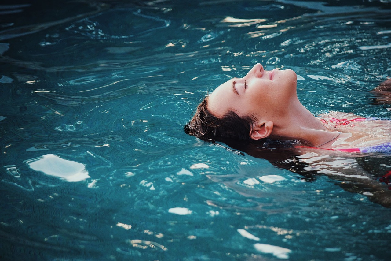 Eine Frau die auf dem Rücken durch das Wasser schwimmt